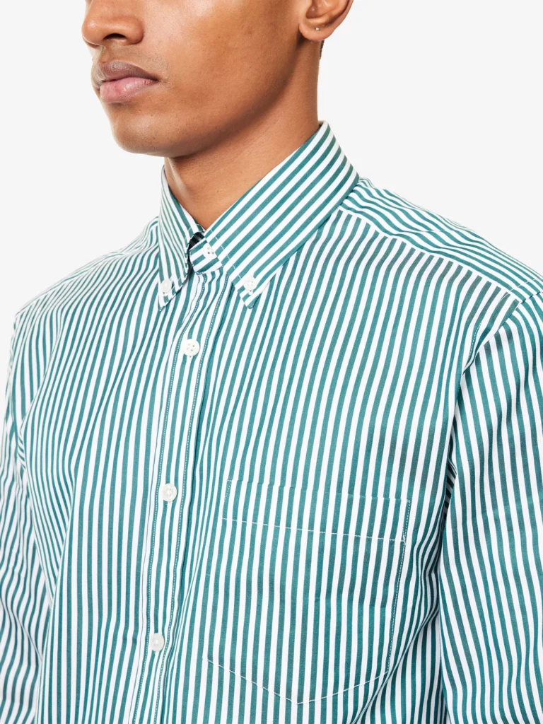 Close-up of a male model wearing a Dunhill green and white striped cotton shirt featuring a button-down collar and chest pocket.